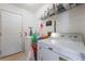 Efficient laundry room with washer, dryer, storage shelves, and convenient access to the exterior at 521 Landra Ln, Henderson, NV 89015