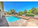 A backyard features a sparkling pool, mature landscaping, and a tranquil oasis at 5396 Splendido Ave, Pahrump, NV 89061