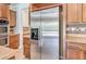 Kitchen showing wood cabinets with a stainless steel refrigerator and tile backsplash at 5396 Splendido Ave, Pahrump, NV 89061