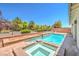 Inviting backyard featuring a pool, spa, mature trees, and a wrought iron fence at 5396 Splendido Ave, Pahrump, NV 89061