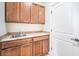 A compact utility sink is installed with wooden cabinetry and a white door at 5396 Splendido Ave, Pahrump, NV 89061
