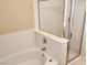 Bright bathroom features a tub with white tiling and a glass-enclosed shower at 5605 Midnight Breeze St, North Las Vegas, NV 89081