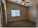 Bedroom with carpet flooring, a ceiling fan, and a window overlooking the backyard at 5605 Midnight Breeze St, North Las Vegas, NV 89081
