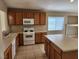 This kitchen has an island, neutral countertops and flooring, and stainless steel appliances at 5605 Midnight Breeze St, North Las Vegas, NV 89081