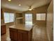 Eat-in kitchen boasts an island, bright lighting, neutral tile flooring, and a sliding glass door to the backyard at 5605 Midnight Breeze St, North Las Vegas, NV 89081