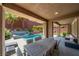 Covered patio with dining area and cushioned seating overlooking pool and landscaping at 5619 Shadow Bend Dr, Las Vegas, NV 89135