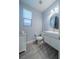 Modern powder room with sleek vanity, round mirror, and gray wood-look flooring at 5619 Shadow Bend Dr, Las Vegas, NV 89135