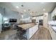 Open concept kitchen and living area with an oversized island and white cabinetry at 5619 Shadow Bend Dr, Las Vegas, NV 89135