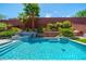 Backyard swimming pool features beautiful blue tile and a brick wall with tiered planting beds at 5619 Shadow Bend Dr, Las Vegas, NV 89135