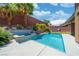 Pool with spa and waterfall feature surrounded by palm trees and landscaping at 5619 Shadow Bend Dr, Las Vegas, NV 89135