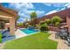 Beautiful backyard pool area with lush landscaping, artificial turf, and patio seating at 5619 Shadow Bend Dr, Las Vegas, NV 89135