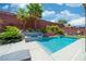 Pool with spa and waterfall feature surrounded by palm trees and landscaping at 5619 Shadow Bend Dr, Las Vegas, NV 89135
