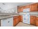 Kitchen with stainless sink, tile backsplash, wood cabinets and white appliances at 5641 Vassar Meadow St, Las Vegas, NV 89148