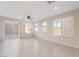 Spacious living room with tile flooring, ceiling fan, and sliding glass door to the backyard at 5641 Vassar Meadow St, Las Vegas, NV 89148