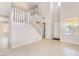 Open living room boasts tile floors, a staircase and natural light from large windows at 5641 Vassar Meadow St, Las Vegas, NV 89148
