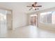 Bright living room with tile flooring, ceiling fan, and sliding glass door to the backyard at 5641 Vassar Meadow St, Las Vegas, NV 89148