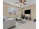 Relaxing living room with tile flooring, a gray couch, and a view out the window at 5667 Foxglove Field St, Las Vegas, NV 89130