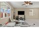 Cozy living room featuring neutral tones, a ceiling fan, and a large window for natural light at 5667 Foxglove Field St, Las Vegas, NV 89130