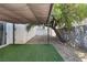 Backyard features an artificial lawn area, rocks, privacy walls, shade cover, and a hanging chair at 5967 Aimless St, Henderson, NV 89011