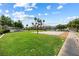 Basketball court in a community area featuring green grass, sidewalks, and nearby condos and trees at 5967 Aimless St, Henderson, NV 89011