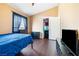 Bedroom features neutral walls, dark wood floors, window with blinds, and a closet with a football themed decoration at 5967 Aimless St, Henderson, NV 89011