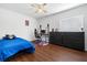 Bedroom features hardwood floors, a ceiling fan, and a desk setup for gaming and a bed with blue sheets at 5967 Aimless St, Henderson, NV 89011