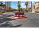 Community entrance with stone monument reading 'Boulder Ranch' surrounded by red flowers, and palm tree-lined street at 5967 Aimless St, Henderson, NV 89011