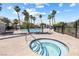 Community pool with hot tub, metal fencing, palm trees, condos, and lounge chairs at 5967 Aimless St, Henderson, NV 89011