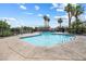 Community pool area featuring palm trees, a large pool, metal fencing, and several condo buildings at 5967 Aimless St, Henderson, NV 89011
