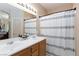 Bathroom featuring a dual sink vanity with white basins, a framed mirror, and neutral decor at 6170 E Sahara Ave # 1076, Las Vegas, NV 89142