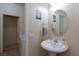 Well-lit powder room featuring a pedestal sink, decorative mirror, and neutral decor at 6170 E Sahara Ave # 1076, Las Vegas, NV 89142