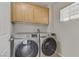 Well-lit laundry room equipped with top-loading washer and dryer, and overhead storage at 6953 Graceful Cloud, Henderson, NV 89011