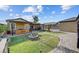 Spacious backyard featuring a cozy covered patio, lush grass, and neatly designed stone pathways at 7036 Winstar St, Las Vegas, NV 89131