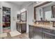 Bathroom featuring dual sinks, dark wood cabinets, and a view of a walk-in closet at 7036 Winstar St, Las Vegas, NV 89131