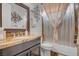 Bathroom boasts granite countertop, brown vanity and framed mirror, complemented by a neutral shower curtain at 7036 Winstar St, Las Vegas, NV 89131