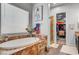 Bright bathroom features a tub, walk-in closet, vanity with granite counters and a decorative mirror at 7036 Winstar St, Las Vegas, NV 89131