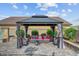 Inviting gazebo with plush seating, offering a perfect outdoor retreat surrounded by greenery at 7036 Winstar St, Las Vegas, NV 89131