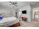 Spacious main bedroom featuring carpeted floors, a ceiling fan, and a sitting bench with a mounted TV above at 7036 Winstar St, Las Vegas, NV 89131