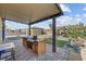 Inviting outdoor kitchen with built-in grill, wood cabinets, and paver patio under a covered pergola at 7036 Winstar St, Las Vegas, NV 89131