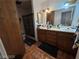 Well-lit bathroom featuring double sinks and wooden vanity with a shower behind a glass enclosure at 7108 Moon Ct, Las Vegas, NV 89145