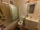 Compact bathroom featuring a bathtub with sliding glass door, toilet, and vanity with medicine cabinet at 7108 Moon Ct, Las Vegas, NV 89145