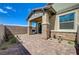 Paver patio with covered area, privacy fence, landscaping, and partial stone-clad wall at 794 Sunny Sagebrush St, Henderson, NV 89011