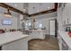 Modern kitchen featuring wooden ceiling beams, white cabinetry, large island with stove and a stainless steel hood at 794 Sunny Sagebrush St, Henderson, NV 89011
