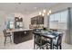 Open kitchen with granite countertops, stainless appliances, dark cabinetry, and a dining area at 794 Sunny Sagebrush St, Henderson, NV 89011