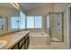 Bright bathroom with soaking tub, glass shower, and dual vanity at 8021 Hilliard Ave, Las Vegas, NV 89128