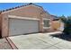 Single-story home with neutral stucco, a two-car garage, and a concrete driveway with brick trim at 8900 Big Bear Pines Ave, Las Vegas, NV 89143