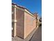 Side view of a stucco home with a decorative trim, showing a narrow walkway and low-maintenance gravel at 8900 Big Bear Pines Ave, Las Vegas, NV 89143