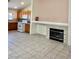 Bright living room with tiled fireplace, open floor plan, and adjacent kitchen at 8900 Big Bear Pines Ave, Las Vegas, NV 89143