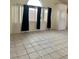 Bright living area featuring neutral tile flooring, large windows with drapes, and an open floor plan at 8900 Big Bear Pines Ave, Las Vegas, NV 89143