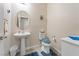 Cozy powder room features a pedestal sink, round mirror, toilet, and decorative accents for a welcoming space at 9288 Valley Betica Ave, Las Vegas, NV 89148
